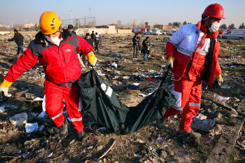 es membres du Croissant-Rouge international rassemblent les corps des victimes autour de l'épave après qu'un Boeing 737-800 d'Ukraine International Airlines transportant 176 personnes se soit écrasé près de l'aéroport Imam Khomeini de Téhéran, tuant tout le monde à bord, à Shahriar, Iran, le 8 janvier 2020. (archives)