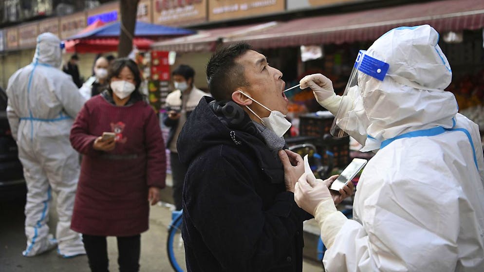 Un homme d'affaires se fait tester dans le district de Xi'an, dans le nord de la Chine, où 13 millions d'habitants sont confinés depuis près de deux semaines (archives).