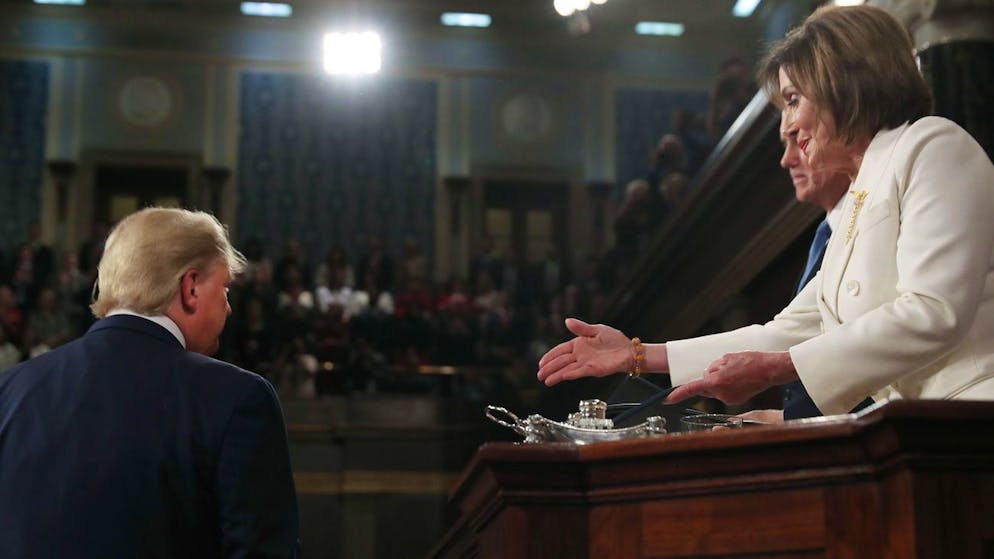President Donald Trump arrives to deliver his State of the Union address to a joint session of Congress in the House Chamber on Capitol Hill in Washington, Tuesday, Feb. 4, 2020, as Speaker Nancy Pelosi reaches to shake his hand. (Leah Millis/Pool via AP)