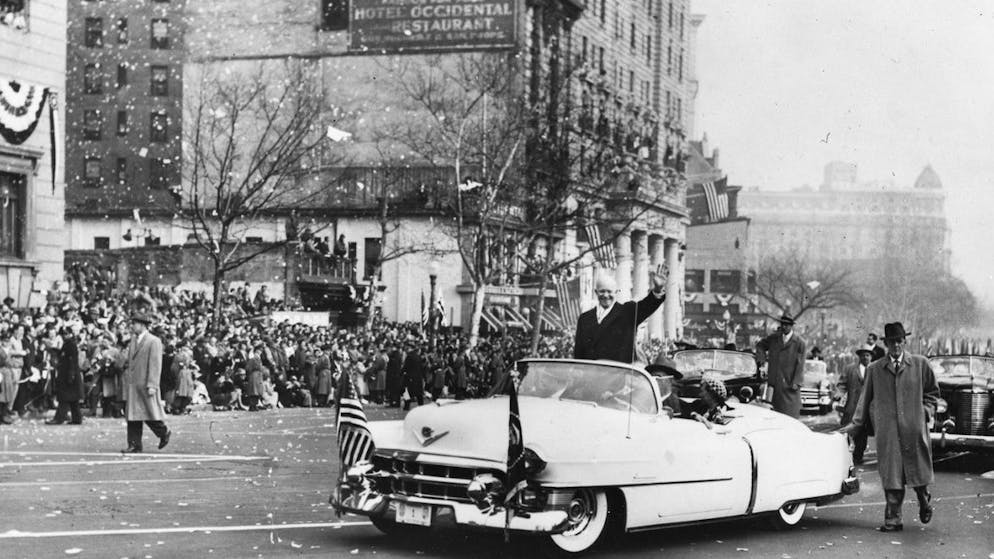 US-Praesident Dwight D. Eisenhower winkt nach seiner Inauguration vom 20. Januar 1953 im offenen Wagen den Menschen in den Strassen von Washington zu. (KEYSTONE/Str)