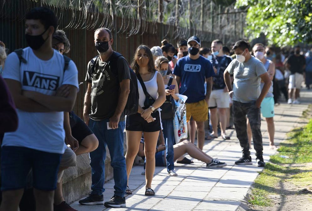 Les gens se tiennent à distance sociale à l'extérieur du parc Centenario pour être testés gratuitement pour COVID-19 à la périphérie de Buenos Aires, en Argentine, le vendredi 31 décembre 2021.