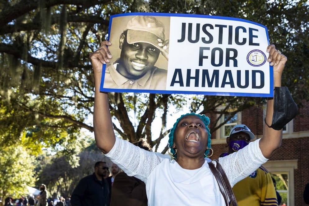 Une personne réagit en brandissant une pancarte après que le jury ait rendu un verdict de culpabilité dans le procès de Travis McMichael, Greg McMichael et Roddie Bryan pour la mort d'un joggeur noir, Ahmaud Arbery, à Brunswick, en Géorgie, le 24 novembre 2021.