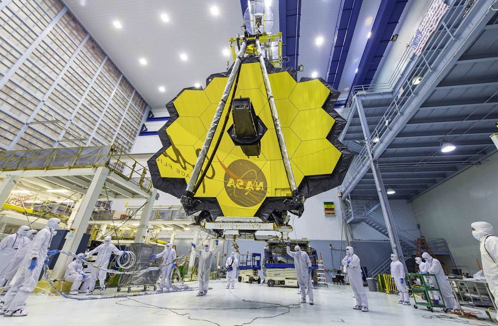 Une photo de fichier non datée mise à disposition par la National Aeronautics and Space Administration (NASA) montre des techniciens de la NASA soulevant le télescope spatial James Webb à l'aide d'une grue et le déplaçant à l'intérieur d'une salle blanche au Goddard Space Flight Center de la NASA dans la Ceinture de verdure, Maryland, États-Unis (publié le 1er décembre 2021).