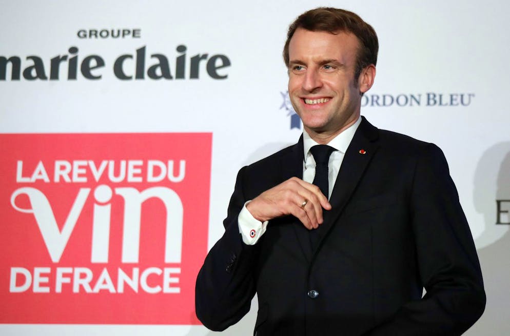 French President Emmanuel Macron receives the 'Personnality of the Year award' by Denis Saverot, unseen, of the wine magazine 'La Revue du Vin' during a ceremony in Paris, France, Thursday, Jan. 6, 2022. (Christophe Petit Tesson, Pool Photo via AP)