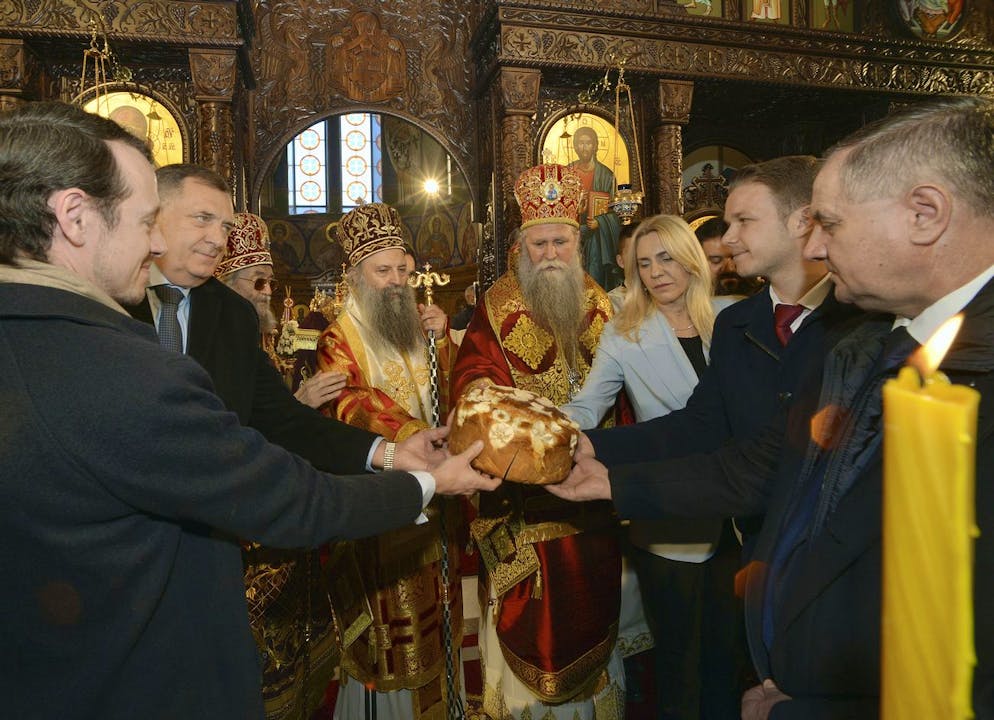 Le leader politique des Serbes de Bosnie, Milorad Dodik, deuxième à gauche, tient un gâteau marquant la Saint-Etienne, le saint patron de la République de Srpska, et le 30e anniversaire avec le patriarche de l'Église orthodoxe serbe Porfirije, quatrième à gauche, Premier ministre de la Republika Srpska Zeljka Cvijanovic, troisième à droite, et le maire de Banja Luka, Drasko Stanivukovic, deuxième à droite, à Banja Luka, dans le nord de la Bosnie, dimanche 9 janvier 2022.