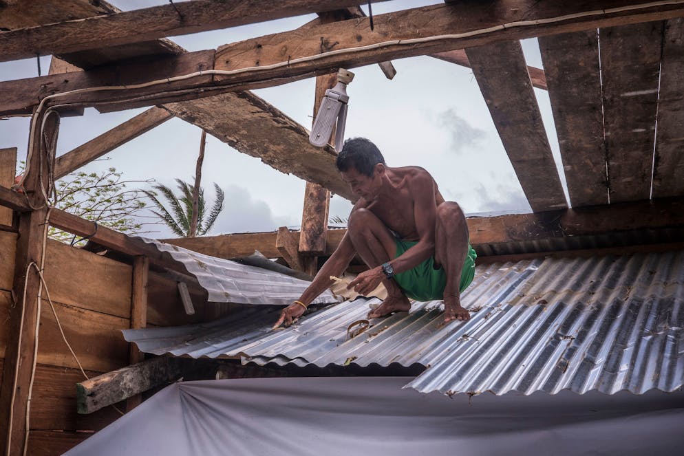 ALFREDO DOLE, 56 years old 
fisherman is fixing his roof. In many islands of the Philippines people know how to build (and fix) a house. They only need some materials, mostly coconut lumber, Amacan for walls and «hiero» metall sheets. Some use Nipa (palm leaves) instead of metall sheets. For a simple house, the locals need materials of roughly 1'000 USD value