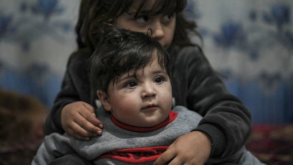 Sohail Ahmadi (front), who was separated from his parents at the airport in the chaos of the US evacuation of Afghanistan in August 2021, plays with the daughter of Hamid Safi, a taxi driver who found Sohail on the ground at Kabul airport and tracked down the family, at Sohail's grandfather's house in Kabul on January 9, 2022. (Photo by Mohd RASFAN / AFP)