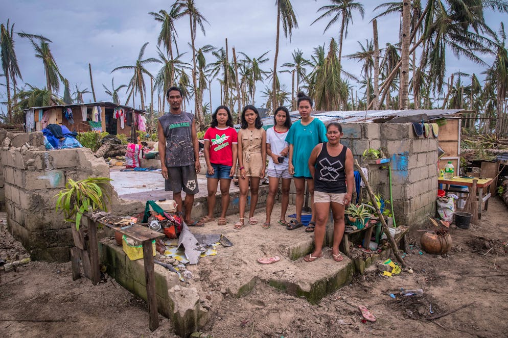 LIZA ANTIPASADO (right in picture), 48 years old, 4 kids and a husband (fisherman). Family portrait from left to right: liza, rosebel, melanie, rose jean, russel, liza may antipasado. Their house is totally damaged. The family is currently staying in their relatives' house for temporary shelter. They haven't been able to celebrate xmas but going to church was enough for them. For long they depend on relief goods. With a broken boat, fishing isn't possible, but even if it was, they can't sell much because theres no ice to cool the fish. All their appliances got wet and damaged.
