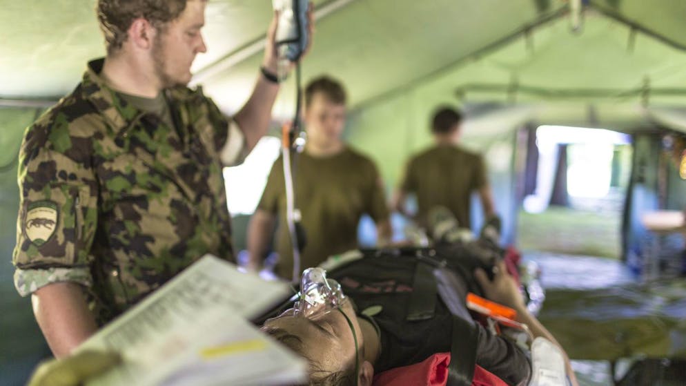 A wounded person is being treated in the medical tent, pictured on site of the medical corps of the Swiss Armed Forces on June 18, 2013, in Buetschwil, canton of St. Gallen, Switzerland. A medical unit of the army runs an exercize together with the police, the Swiss protection & support service and the fire brigade. They simulate an earth quake with many wounded people trapped in the rubble. The medical corps members set up their tent in order to treat the wounded people there. (KEYSTONE/Gaetan Bally)
Ein Verletzter wird im Sanitaetszelt versorgt, aufgenommen bei den Sanitaetstruppen der Schweizer Armee am 18. Juni in Buetschwil, Kt. St. Gallen. Eine Sanitaetseinheit der Armee fuehrt mit Polizei, Zivilschutz und der Feuerwehr eine Uebung durch. Sie simulieren ein Erdbeben mit vielen eingeklemmten Verletzten. Die Sanitaeter bauen zuerst ihr Zelt auf und nehmen danach die ersten Verletzten in Empfang. (KEYSTONE/Gaetan Bally)