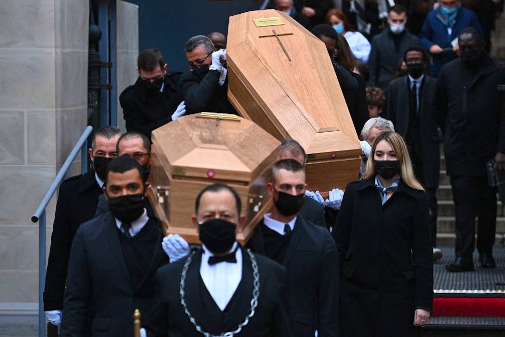 TOPSHOT - Pallbearers carry the coffins as they leave at the Madeleine church during the funeral ceremony of French TV hosts and science writers, twin brothers Igor and Grichka Bogdanoff, in Paris, on January 10, 2022. - The twins who became the faces of a famed 1980s science TV programme before winning notoriety for their cosmetic surgery, died within a week from each other on December 28, 2021 (Grichka) and January 3, 2022 (Igor), aged 72, from Covid-19, after refusing the vaccination. (Photo by Christophe ARCHAMBAULT / AFP) (Photo by CHRISTOPHE ARCHAMBAULT/AFP via Getty Images)