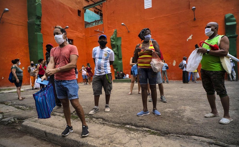 Les acheteurs portant des masques protecteurs par mesure de précaution contre la propagation du coronavirus, attendent leur tour pour entrer dans un magasin pour acheter de la nourriture, à La Havane. (archives)