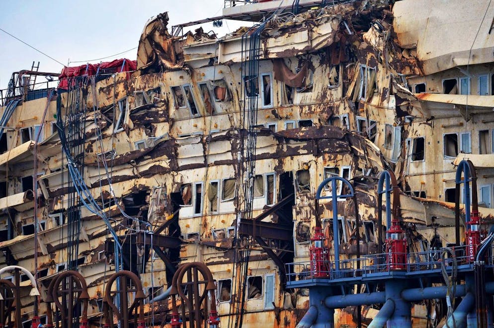 epa04334065 The Italian cruise liner Costa Concordia sits in a dock inside of Voltri Port in Genoa, Italy, 28 July 2014. The Costa Concordia dismantling operations are predicted to last two years. The cruise liner was made floating again on 14 July, 30 months after the cruise ship hit a reef and partly capsized off the island of Giglio on 13 January 2012 after being steered too close to the shore, seeing thirty-two of the 4,229 people onboard killed. EPA/LUCA ZENNARO
