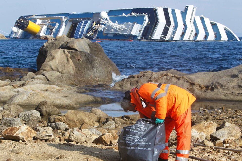 Un ouvrier ramasse des matériaux du navire de croisière Costa Concordia échoué au large de l'île toscane de Giglio, en Italie, samedi 4 février 2012.