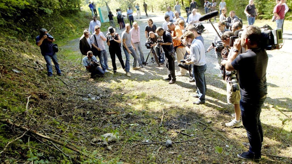 epa03389454 Journalists take images and footage at the site where four people died in a shooting at a parking in Chevaline, near the Annecy Lake, France, 08 September 2012. French prosecutors launched a formal murder investigation 07 September over the killings of three members of a British family and a French cyclist in the Alps, and said they were exploring a possible family row over money. Two relatives of the British girls whose parents were gunned down in the French Alps in the meantime have arrived in France and were expected to meet with the youngest survivor, France Info radio reported 08 September. EPA/NORBERT FALCO/LE DAUPHINE FRANCE OUT
