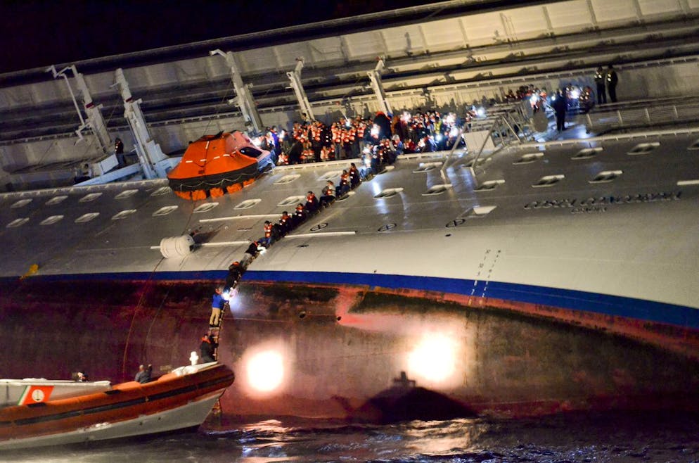 Sur cette photo publiée par le journal Corriere Fiorentino vendredi 2 mars 2012 et prise le 13 janvier 2012, des personnes non identifiées abandonnent le navire de croisière Costa Concordia couché sur son côté tribord après qu'il se soit échoué au large de la côte de l'île Isola del Giglio, en Italie.