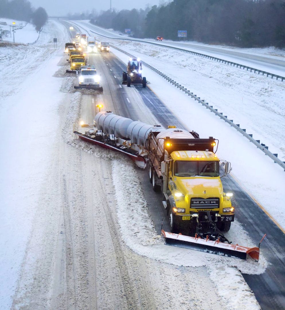 Une série de NCDOT et de camions contractuels et de niveleuses charrues l'Interstate 40 près de Lewisville-Clemmons Road à Clemmons, Caroline du Nord, en fin d'après-midi le dimanche 16 janvier 2022.