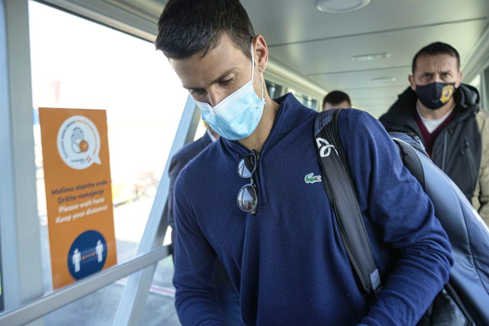 Novak Djokovic looks as his documents after landing in Belgrade, Serbia, Monday, Jan. 17, 2022. Djokovic arrived in the Serbian capital following his deportation from Australia on Sunday after losing a bid to stay in the country to defend his Australian Open title despite not being vaccinated against COVID-19.(AP Photo/Darko Bandic)