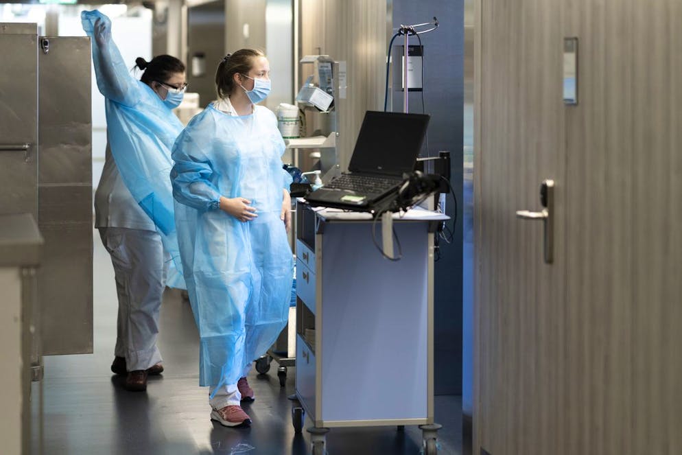 Le personnel soignant se prepare a la visite des personnes atteintes du Covid-19 dans l'UnitŽ Covid du service de mŽdecine interne lors de la 5eme vague de la pandemie de Coronavirus (Covid-19) le mardi 11 janvier 2022 au Centre Hospitalier Universitaire Vaudois, CHUV, a Lausanne. (KEYSTONE/Gaetan Bally)