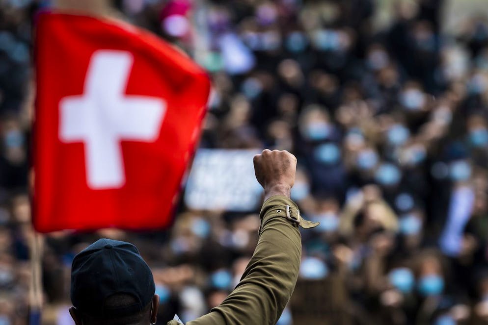 People demonstrate against racism after the worldwide movement of the Black Lives Matter (BLM) protest against the recent death of George Floyd in Lausanne, Switzerland, Saturday, June 13, 2020. (KEYSTONE/Jean-Christophe Bott) Des personnes manifestent sur la place de la Riponne lors d'un rassemblement contre le racisme et les violences policieres le samedi 13 juin 2020 a Lausanne. (KEYSTONE/Jean-Christophe Bott)