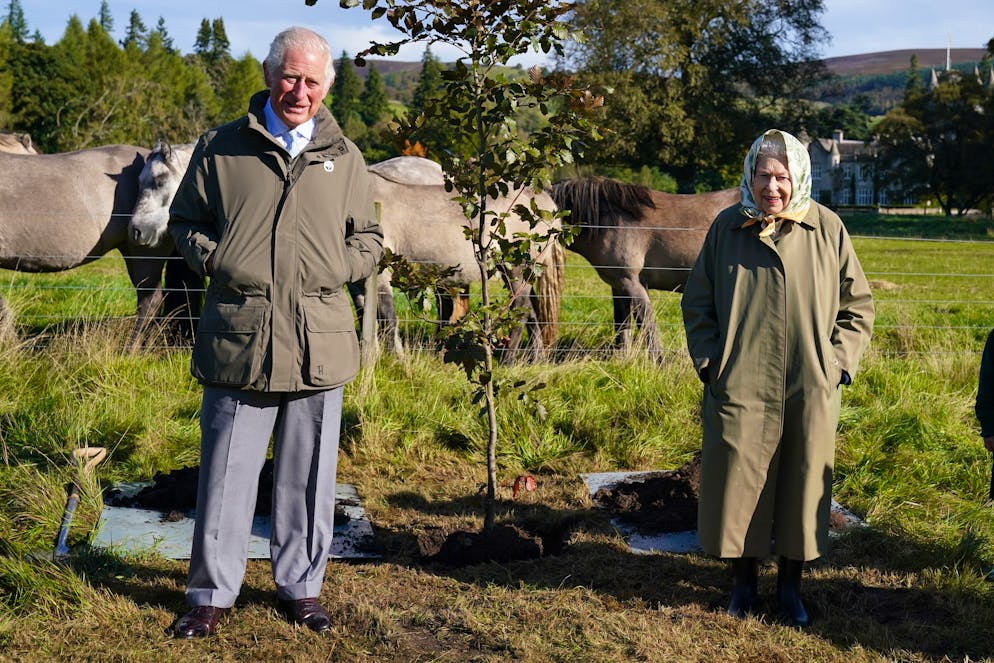 CRATHIE,  UNITED KINGDOM - OCTOBER 1:  Queen Elizabeth II and Prince Charles, Prince of Wales (known as the Duke of Rothesay when in Scotland) pose after planting a tree at the Balmoral Cricket Pavilion, to mark the start of the official planting season for the Queen's Green Canopy (QGC), on October 1, 2021 near Crathie, Scotland. The QGC is a UK-wide Platinum Jubilee initiative which will create a lasting legacy in tribute to the Queen's 70 years of service to the nation, through a network of trees planted in her name. (Photo by Andrew Milligan-WPA Pool/Getty Images)