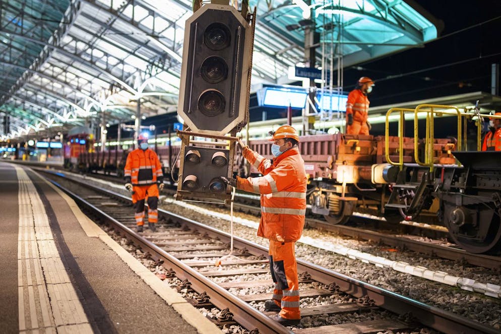Des personnes remplacent des signaux sur les voies de la gare CFF de Lausanne a l'occasion du week-end de travaux pour la mise en place du nouvel enclenchement, ce dimanche 21 mars 2021 a Lausanne. (KEYSTONE/Valentin Flauraud)
