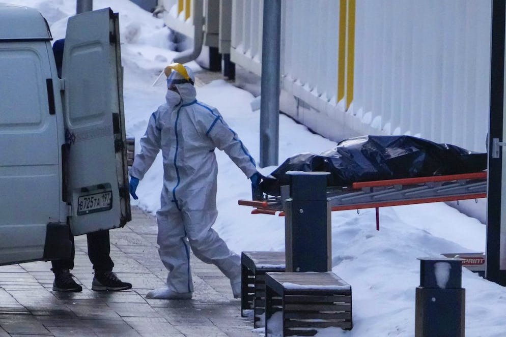 Medical workers carry a body to a van outside a COVID-19 hospital in Kommunarka, outside Moscow, Russia, Thursday, Jan. 27, 2022. Russia's state coronavirus task force has reported more than 11.3 million confirmed cases and over 328 thousands deaths, by far the largest death toll in Europe. (AP Photo/Pavel Golovkin)