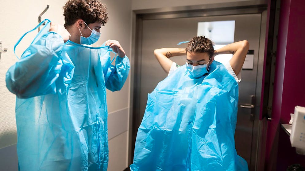 137 neue Spitaleinweisungen: Personal des Waadtländer Universitätsspitals Lausanne beim Anlegen der Schutzkleidung zur Pflege Covid-Kranker.