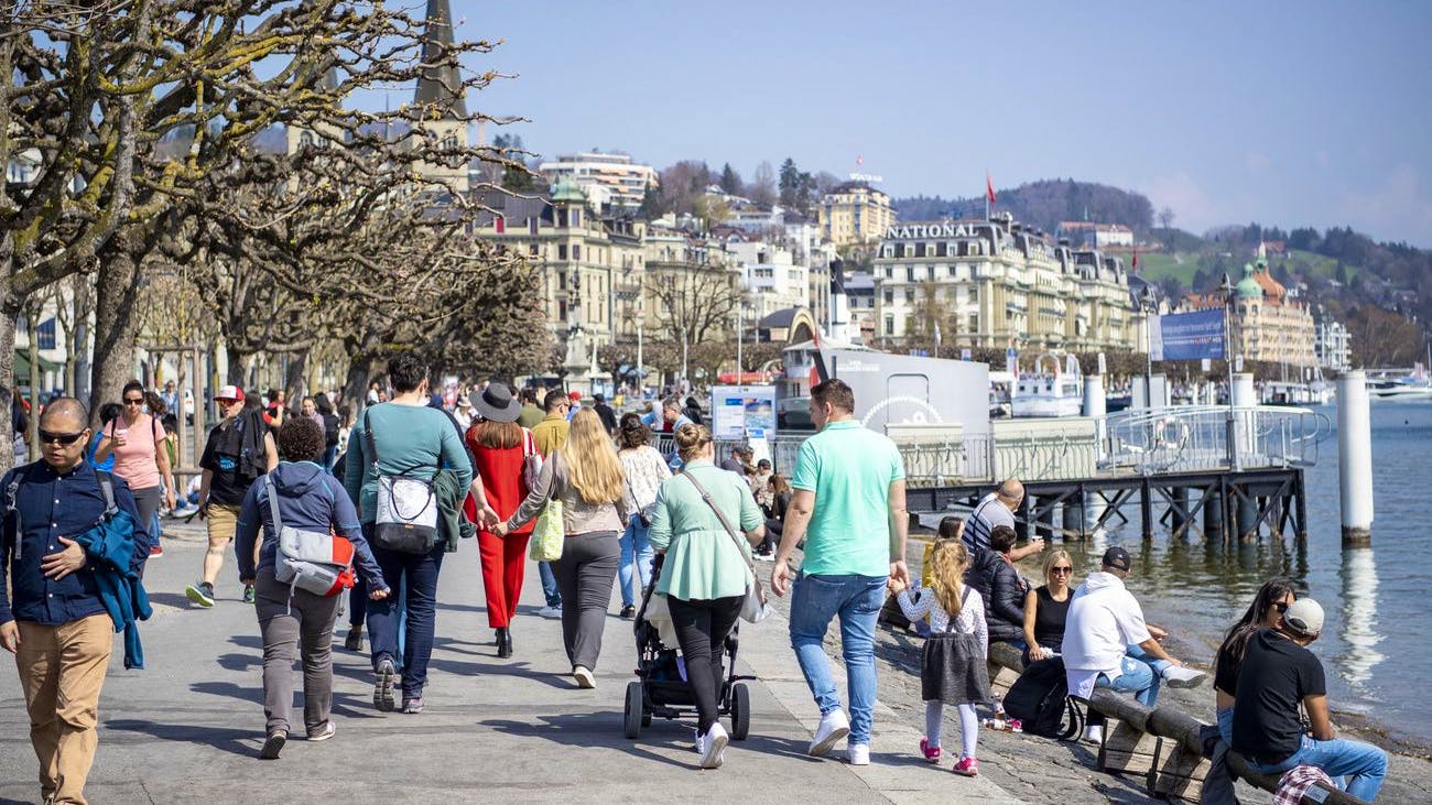 Menschen geniessen das Frühlingswetter an die Seepromenade von Luzern im April 2021. 