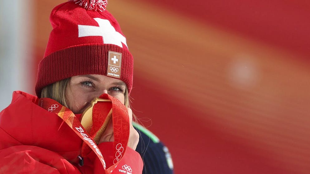 Corinne Suter, of Switzerland, gold, reacts during the medal ceremony for the women's downhill at the 2022 Winter Olympics, Tuesday, Feb. 15, 2022, in the Yanqing district of Beijing. (AP Photo/Alessandro Trovati)