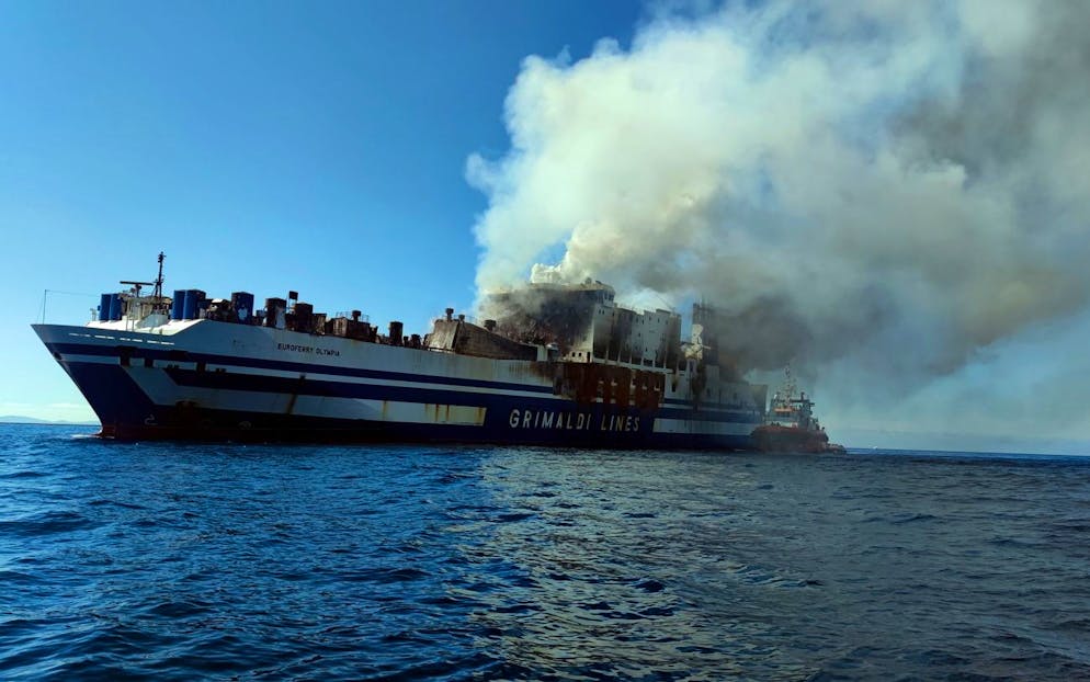 epa09771564 Firefighting forces continue their battle against pockets of fire and extremely high temperatures on the burning ferry 'Euroferry Olympia' after a fire that broke out onboard while sailing off Ereikousa island, Ionian Sea, Greece, 19 February 2022. The Greek Fire Brigade's special disaster unit (EMAK) said they will not be able to search for the 12 people still missing, among them 3 Greek nationals, unless smoke and high temperatures subside, as these can reach up to 500C in some parts of the ferry. Firefighters were trying to put out the fire operating from onboard the tug boats and the fire brigade's firefighting vessel. A total of 280 passengers and crew have been evacuated, including two foreign nationals who were not on the passenger list, while another 12 cannot be accounted for. The fire broke out on 18 February as the ferry was sailing off Erikoussa, near Corfu, while carrying out the journey from Igoumenitsa to the port of Brindisi in Italy. EPA/STR