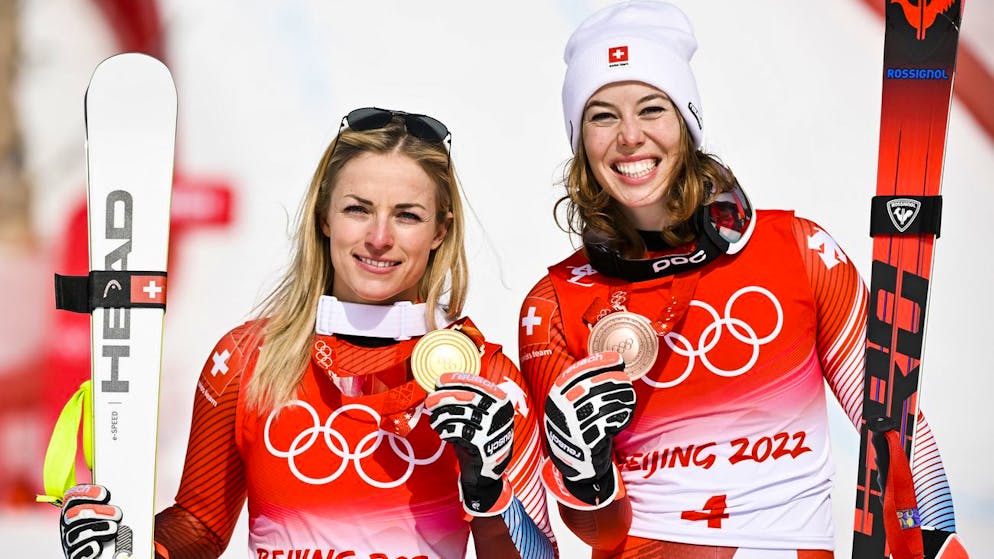 Gold medalist Lara Gut-Behrami of Switzerland, left, celebrates with bronze medalist Michelle Gisin of Switzerland, right, during the victory ceremony of the women's Alpine Skiing Super-G race at the 2022 Olympic Winter Games in Yanqing, China, on Friday, February 11, 2022. (KEYSTONE/Jean-Christophe Bott)