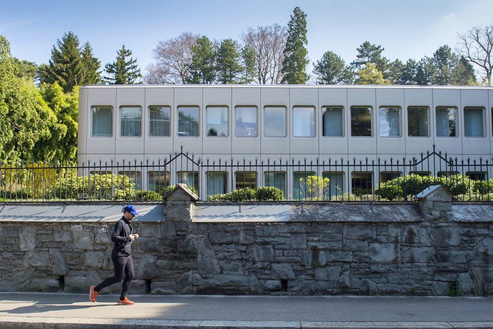 Un homme court devant le siège de Gazprombank sur la Zollikerstrasse, photographié à Zurich