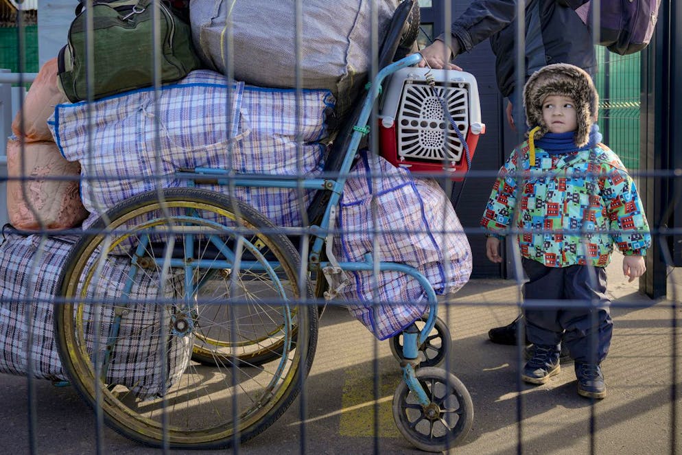Une famille passe du territoire contrôlé par les séparatistes pro-russes aux zones contrôlées par le gouvernement ukrainien à Stanytsia Luhanska, le seul point de passage ouvert tous les jours, dans la région de Lougansk, dans l'est de l'Ukraine, le mardi 22 février 2022.