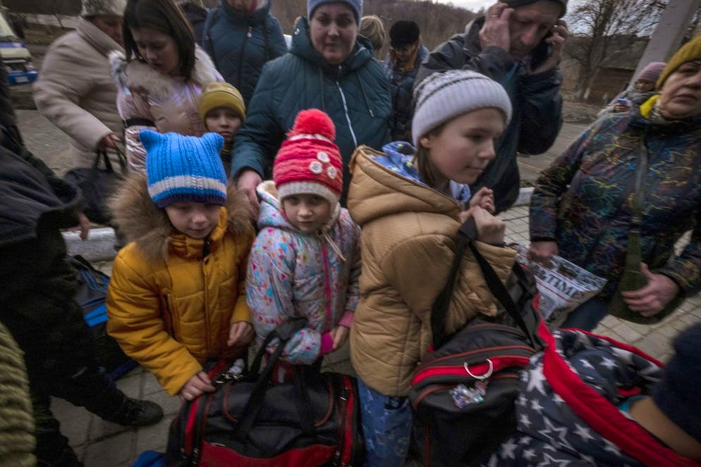 Families line up to board a Kyiv bound train at a station in Severodonetsk, the Donetsk region, eastern Ukraine, Thursday, Feb. 24, 2022. Russia launched a wide-ranging attack on Ukraine on Thursday, hitting cities and bases with airstrikes or shelling, as civilians piled into trains and cars to flee. (AP Photo/Ricard Garcia Vilanova)