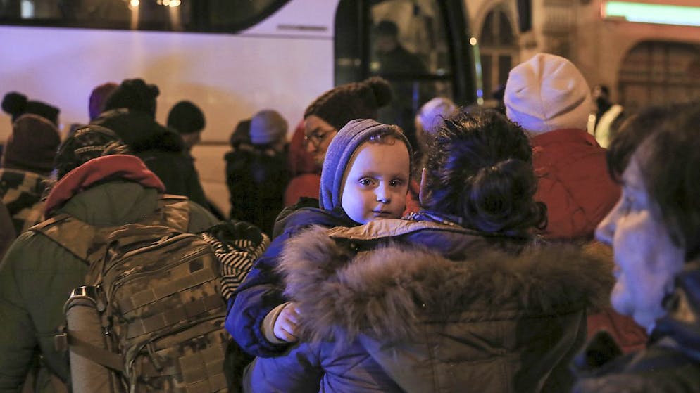 Donne e bambini ucraini salgano su un bus in direzione di Varsavia
