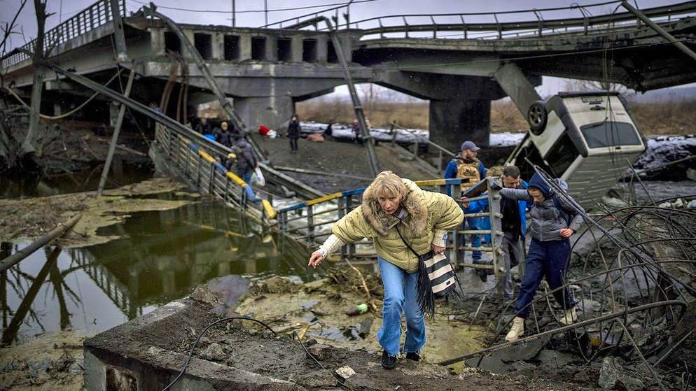 Alcuni civili cercano di scappare tra le macerie di Kiev, il 2 marzo 2022.