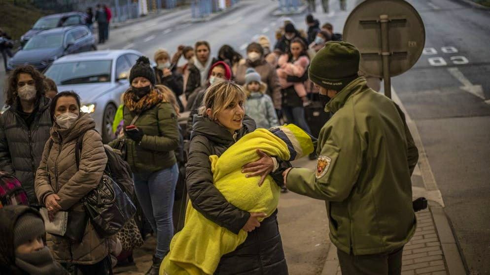 Una donna con il suo bambino in braccio al confine ucraino-slovacco mercoledì 2 marzo 2022. 
