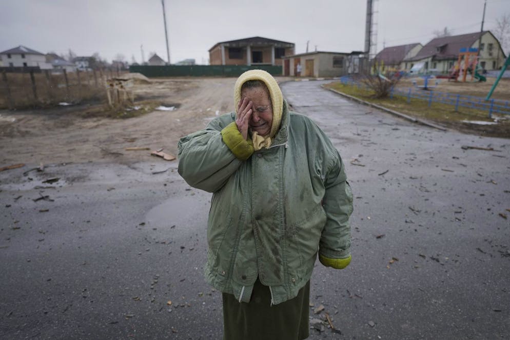 Une femme pleure devant des maisons endommagées par une frappe aérienne russe, selon des habitants, à Gorenka, à l'extérieur de la capitale Kiev, en Ukraine, le mercredi 2 mars 2022.