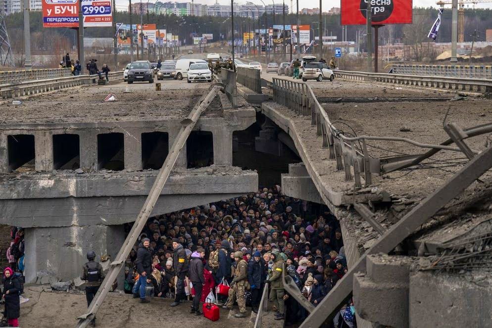 Ucraini si affollano sotto un ponte distrutto mentre cercano di fuggire attraverso il fiume Irpin alla periferia di Kiev, Ucraina, sabato 5 marzo 2022.