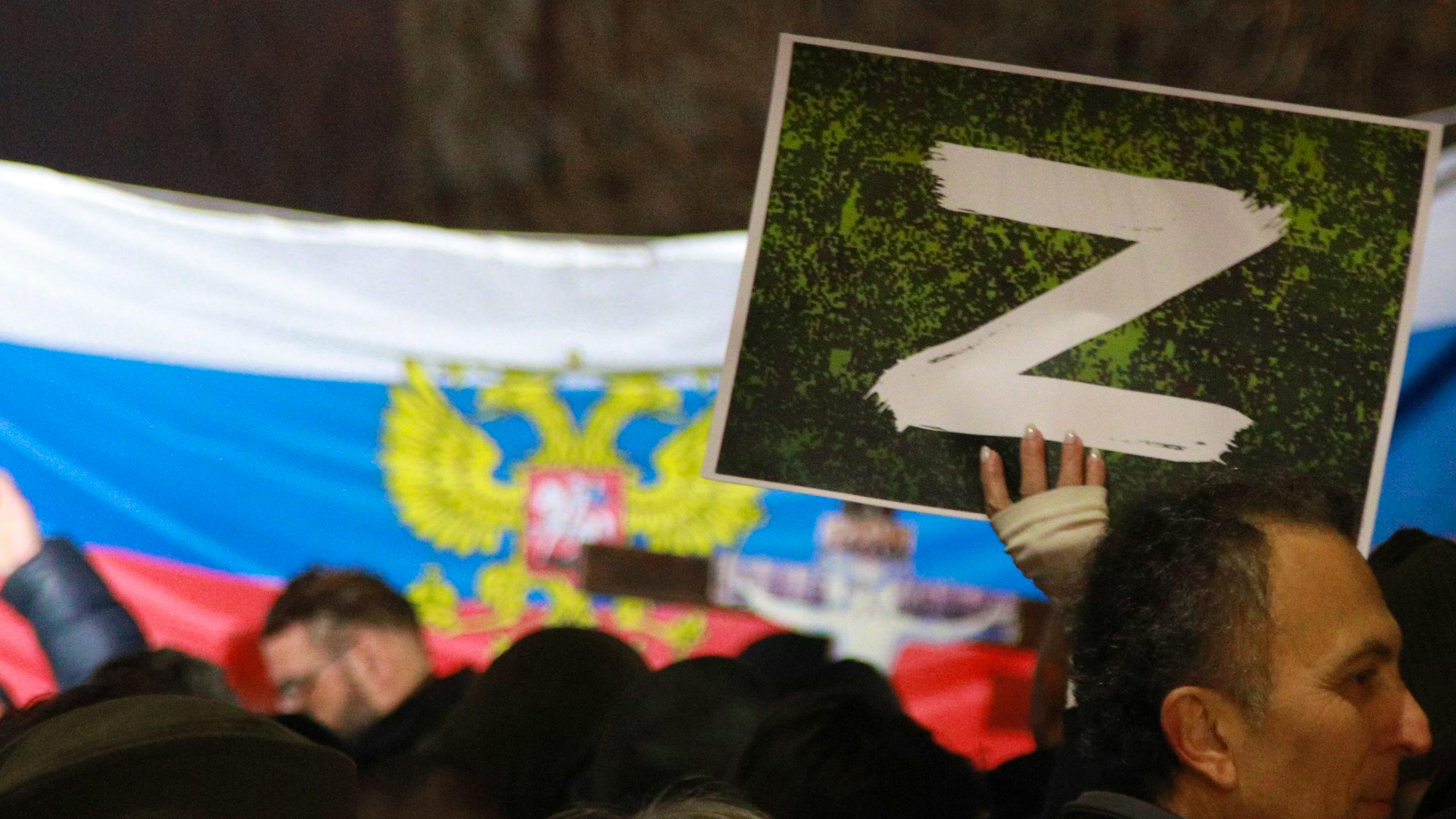 Unterstützer von Putins Angriff auf die Ukraine in Belgrad, Serbien, halten auf einer Demonstration ein Schild mit einem weissen Z in die Höhe. 