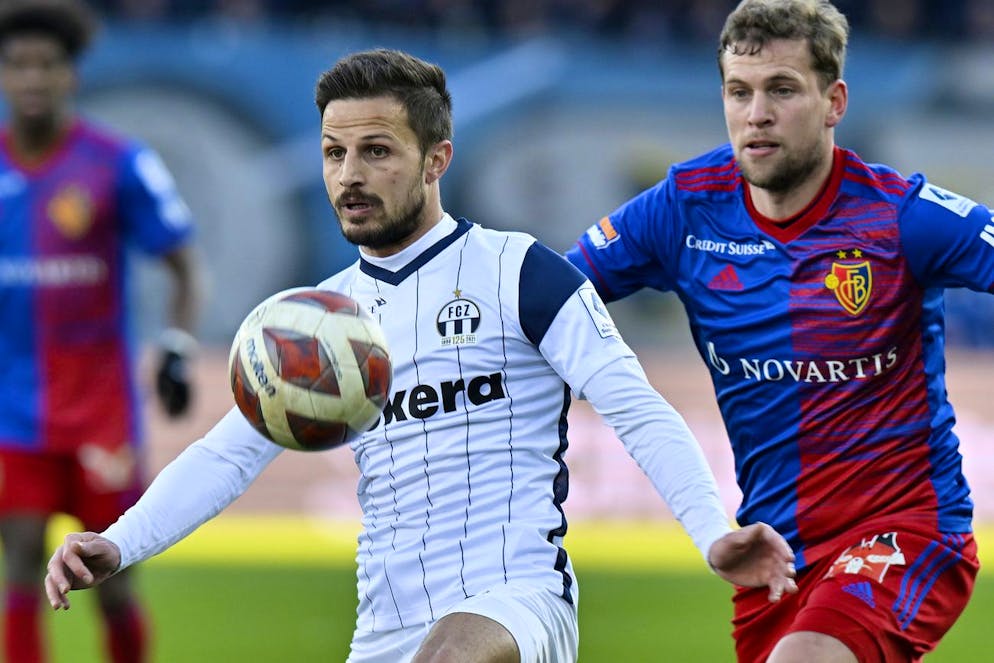 Der Zuercher Antonio Marchesano, links, gegen den Basler Fabian Frei, rechts, beim Fussball Meisterschaftsspiel der Super League FC Zuerich gegen den FC Basel im Stadion Letzigrund in Zuerich am Sonntag, 27. Februar 2022. (KEYSTONE/Walter Bieri)