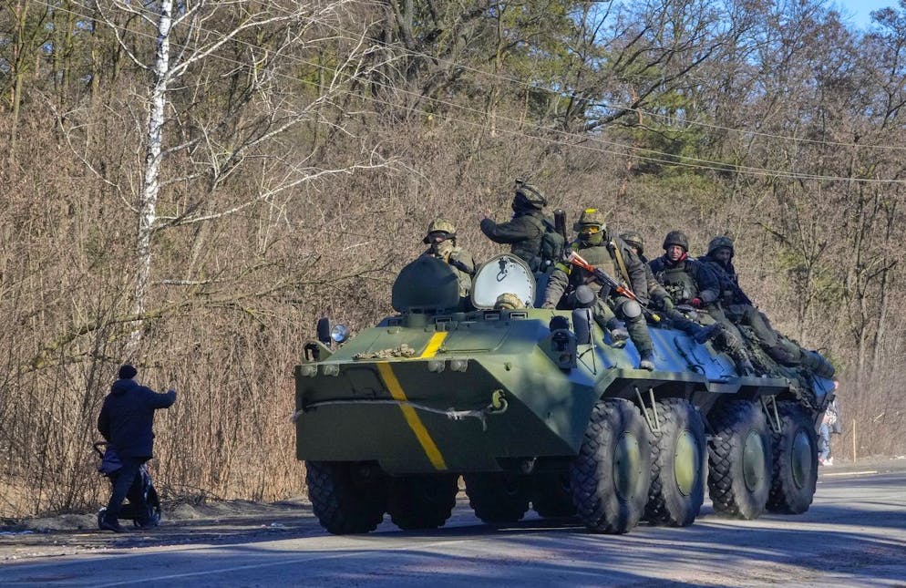 A man pushes a baby stroller as he waves to Ukrainian soldiers on an armoured personnel carrier passing by in the Vyshgorod region close to Kyiv, Ukraine, Thursday, March 10, 2022. RussiaâÄ™s two-week-long war in Ukraine has killed thousands of people and forced more than 2 million others to flee the country, shaking the foundations of European security. (AP Photo/Efrem Lukatsky)