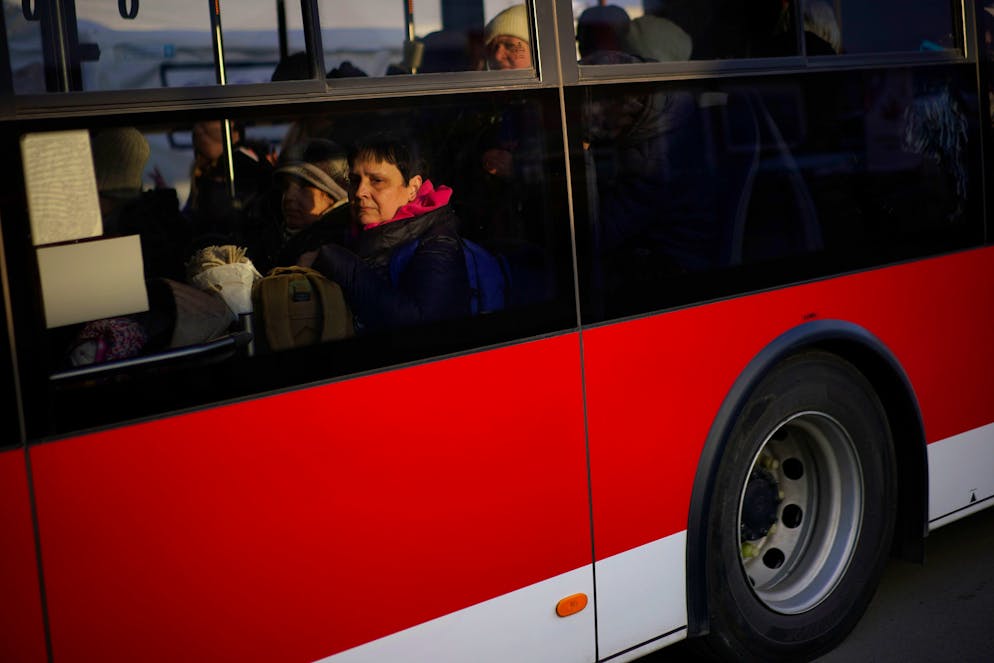 Refugees fleeing war in neighboring Ukraine board on a bus as they arrive at the Medyka border crossing, Poland, Thursday, March 10, 2022. (AP Photo/Daniel Cole)
