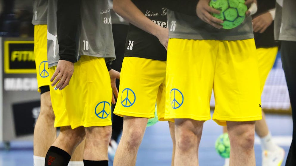 Berlin handball players wear peace signs prior to their Bundesliga match between THW Kiel - Fuechse Berlin in Kiel, Germany, Sunday, March 13, 2022. (Frank Molter/dpa via AP)
