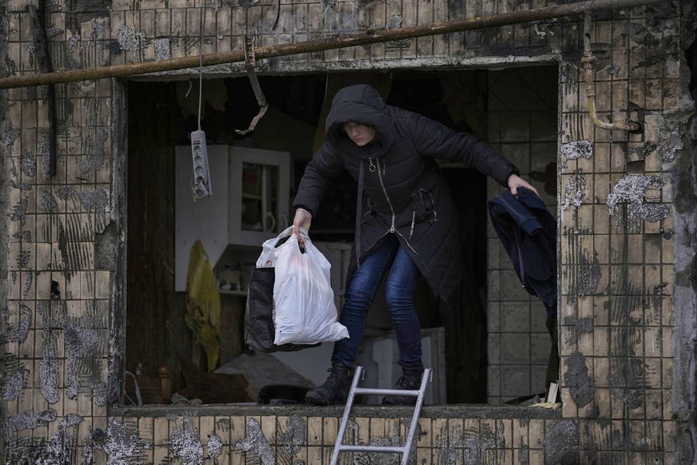 A local resident searches for her belongings in an apartment building after it was hit by artillery shelling in Kyiv, Ukraine, Monday, March 14, 2022. (AP Photo/Vadim Ghirda)