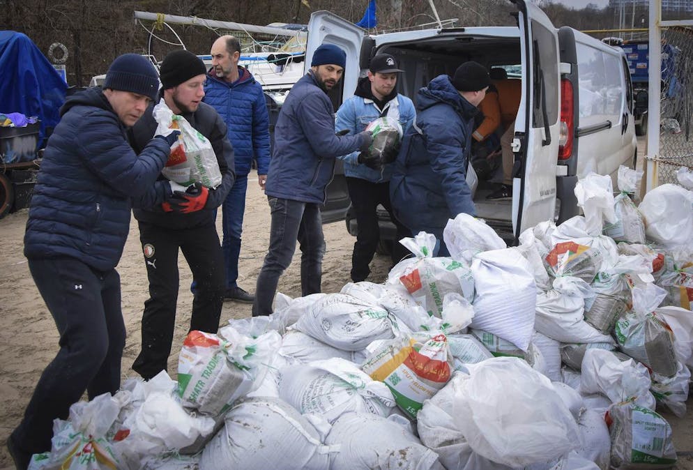 Des volontaires chargent des sacs de sable à l'arrière d'un bus pour construire des barricades à Odessa, en Ukraine, le samedi 5 mars 2022.