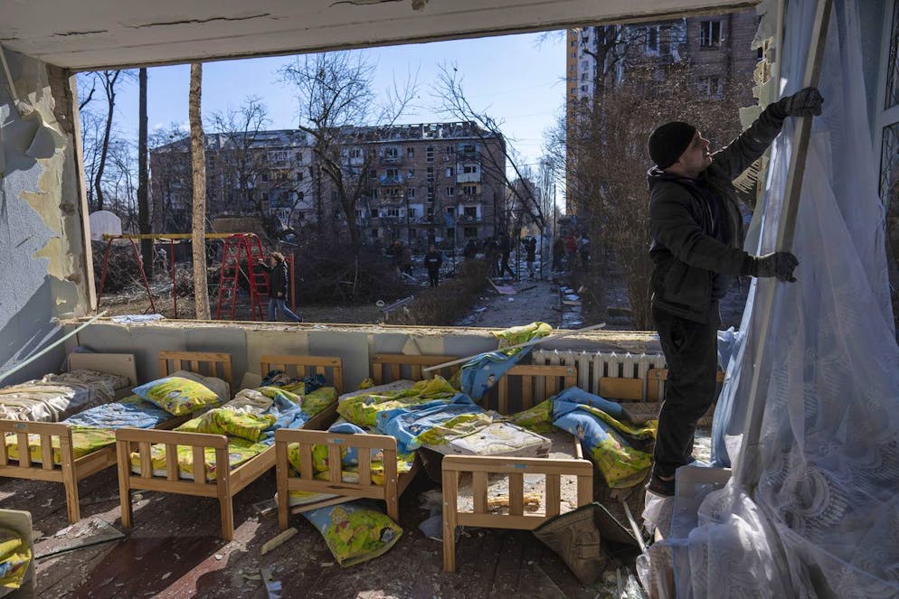A man removes a destroyed curtain inside a school damaged among other residential buildings in Kyiv, Ukraine, Friday, March 18, 2022. Russian forces pressed their assault on Ukrainian cities Friday, with new missile strikes and shelling on the edges of the capital Kyiv and the western city of Lviv, as world leaders pushed for an investigation of the Kremlin's repeated attacks on civilian targets, including schools, hospitals and residential areas. (AP Photo/Rodrigo Abd)