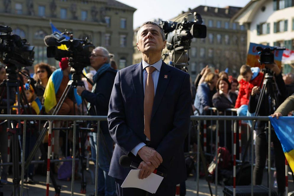 Swiss Federal President Ignazio Cassis listens to the speech of Ukrainian President Volodymyr Zelensky, during a demonstration against the Russian invasion of Ukraine in front of the Swiss parliament building in Bern, Switzerland, Saturday, March 19, 2022. (KEYSTONE/Peter Klaunzer)