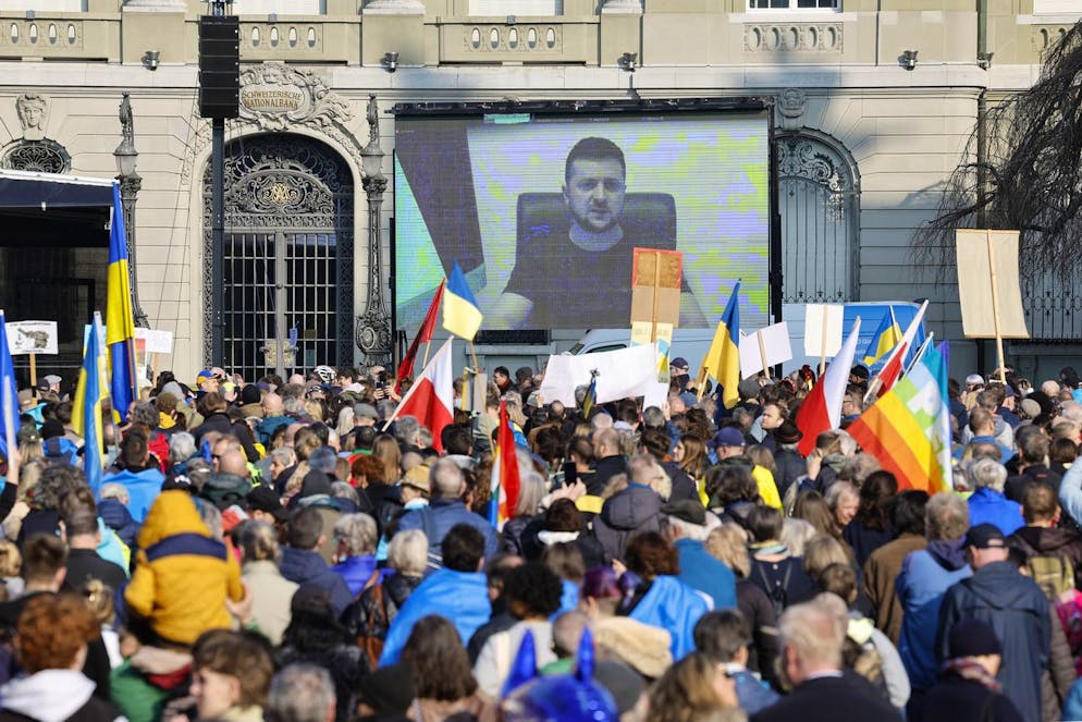 Ukrainian President Volodymyr Zelensky is displayed on a screen during a demonstration against the Russian invasion of Ukraine in front of the Swiss parliament building in Bern, Switzerland, Saturday, March 19, 2022. (KEYSTONE/Peter Klaunzer)