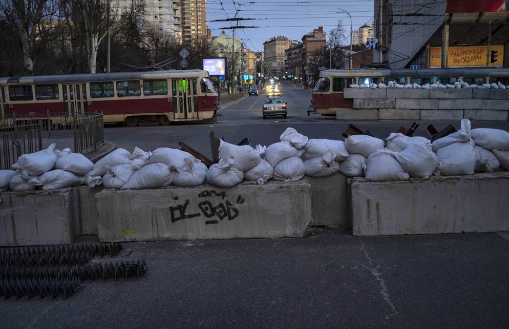 A driver passes through a barricade built by territorial defense units downtown in Kyiv, Ukraine, Saturday, March 19, 2022. (AP Photo/Rodrigo Abd)